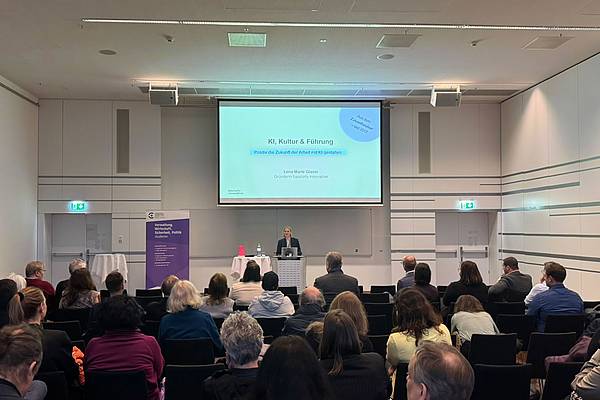 © HCW Lena Marie Glaser präsentiert am Rednerpult ihre Folien vor dem sitzenden Publikum.