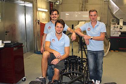 © HCW Gruppenfoto von drei jungen Männern in hellblauen Team Shirts in einer Werkstatt