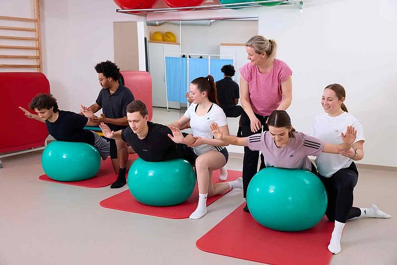 © HCW/Schedl Studierende üben mit Patient*innen auf Therapiebällen