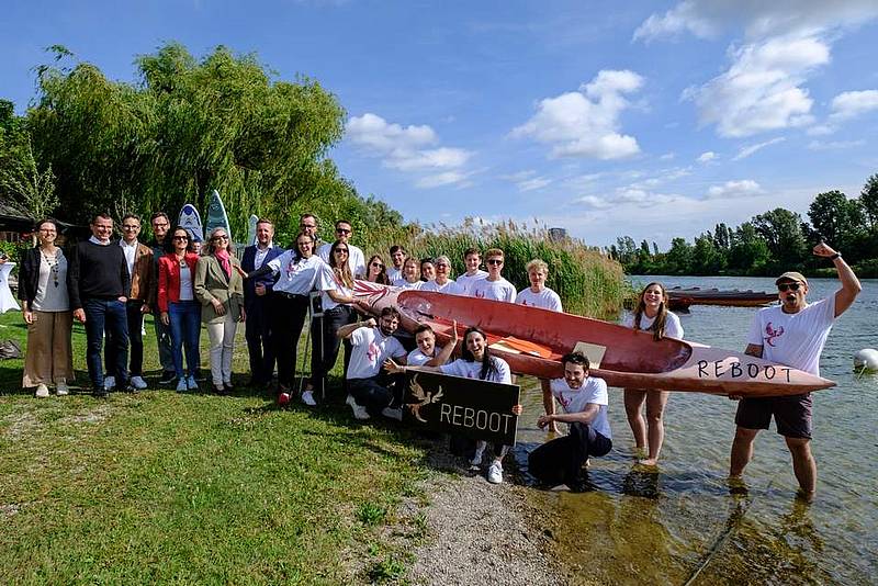 © HCW Eine Gruppe trägt ein Kanu in einen Fluss