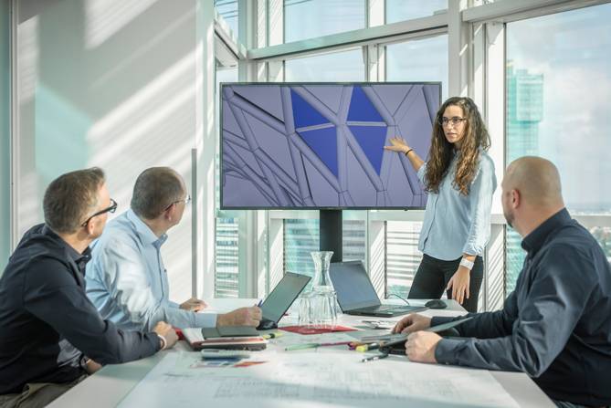 © STRABAG SE Personen, die eine Besprechung haben und einer Präsentation folgen