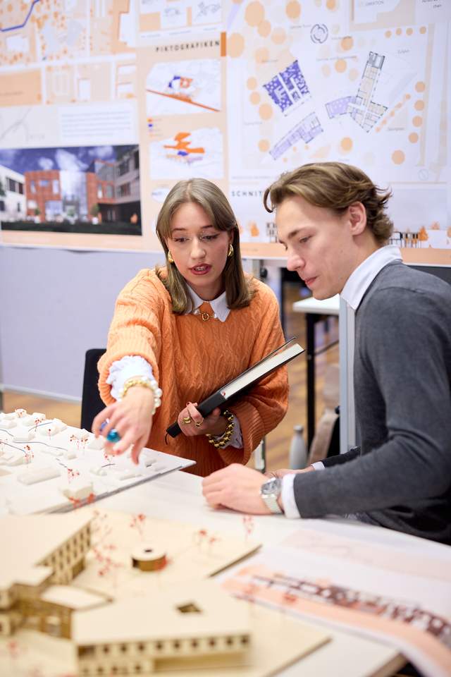 © HCW / Schedl 2 Personen sprechen über ein Architekturmodell