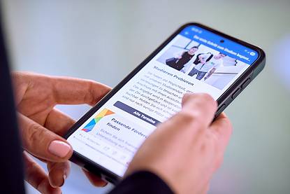 © HCW/Schedl Nahaufnahme eines Smartphones in den Händen einer Person