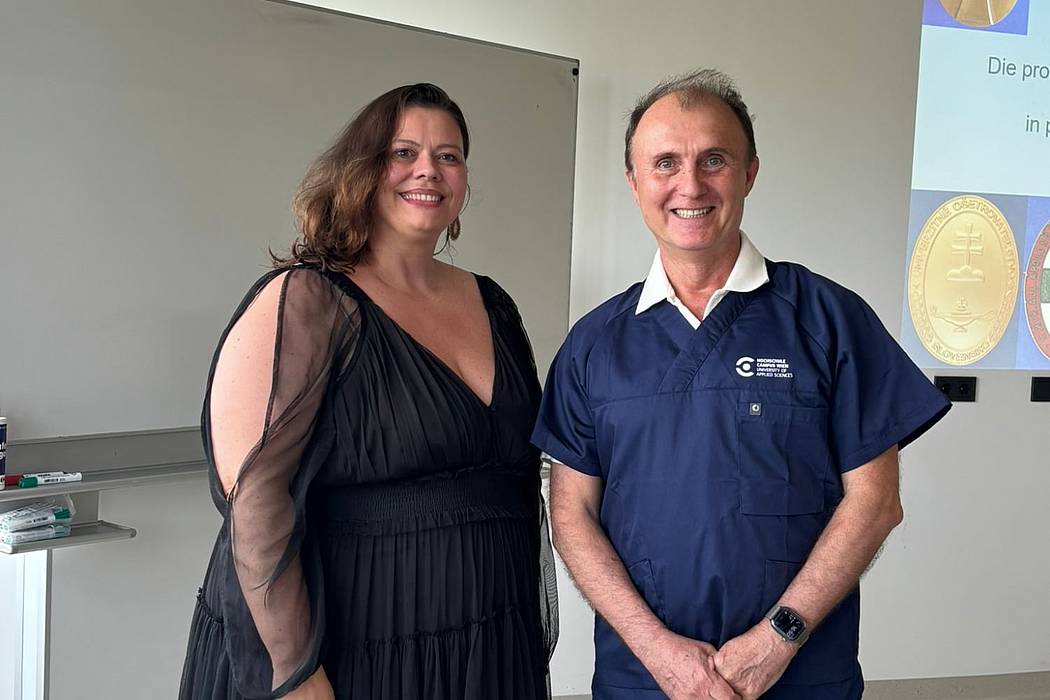 © HCW/privat Eine Frau und ein Mann vor einer Präsentation, auf der Orden und Broschen zu sehen sind