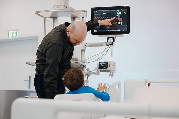 © Hochschule Campus Wien/Lederer Vater und Sohn im OPIC der Hochschule Campus Wien, bei der Betrachtung eines technischen Geräts.