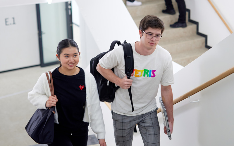 © HCW/Schedl Zwei Studierende gehen die Stiege im House of Science and Engineering der F H Campus Wien hoch