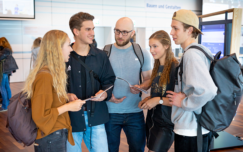 © HCW/Schedl Eine Gruppe Studierende unterhält sich im Foyer der Hochschule