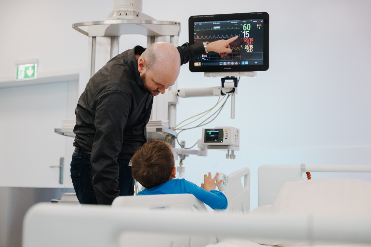 © Hochschule Campus Wien/Lederer Vater und Sohn im OPIC der Hochschule Campus Wien, bei der Betrachtung eines technischen Geräts.